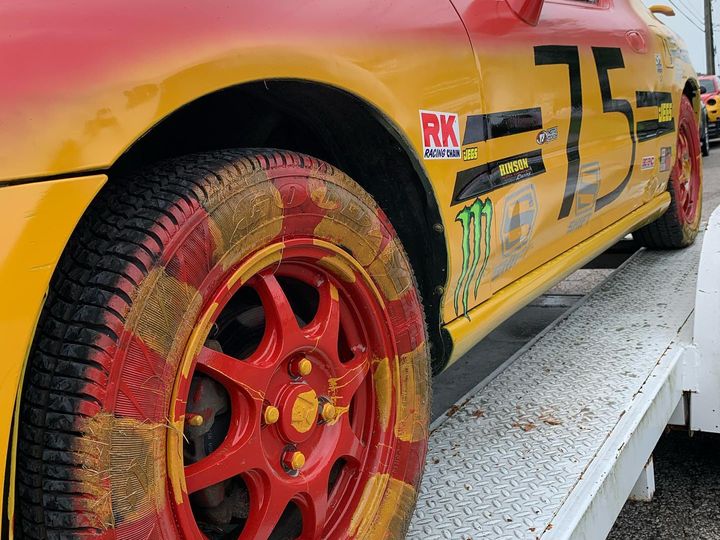Number 75 race car in red and yellow on a trailer