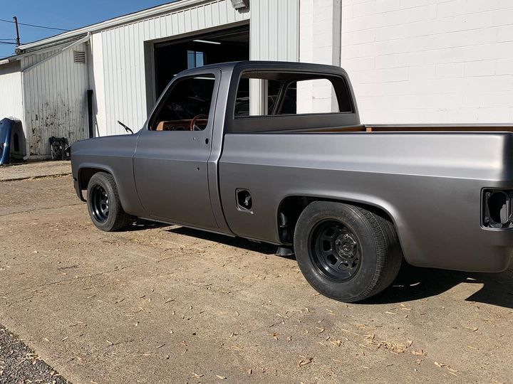 Side view of the satin charcoal square-body pickup on black wheels